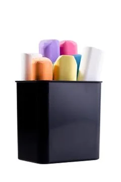 Multi-colored chalk in a black plastic glass on a white isolated background. Stock Photos
