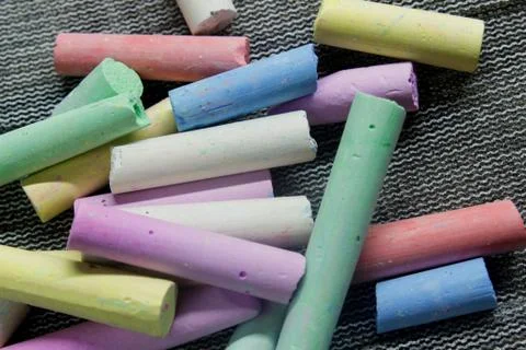 Multi-colored chalk on a gray background close-up. Stock Photos
