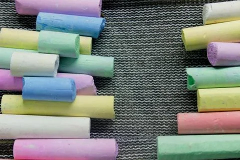 Multi-colored chalk on a gray background close-up. Stock Photos