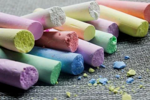 Multi-colored chalk on a gray background close-up. Stock Photos