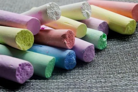 Multi-colored chalk on a gray background close-up. Stock Photos