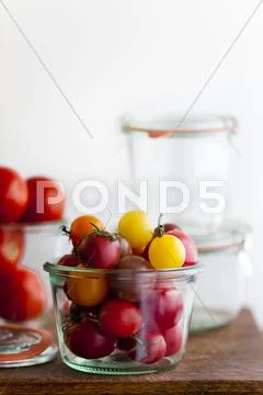 Multi-Colored Cherry Tomatoes in a Glass Container Stock Photos