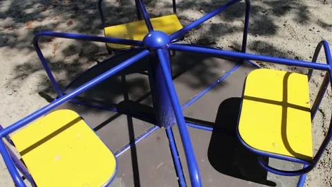 Multi-colored children's carousel in children's park is spinning and waiting for Stock Footage