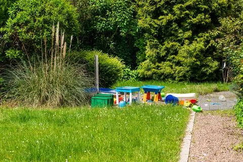 Multi-colored children's plastic toys scattered on a green lawn. Stock Photos