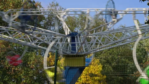 Multi-Colored Children's Swing Chamomile is Spinning in the Autumn Park Stock Footage 217424274