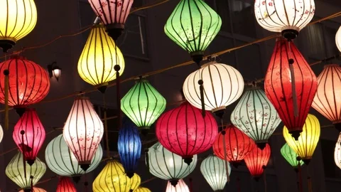 Multi-colored Chinese lanterns swing in the wind during the day. Stock Footage 119556358