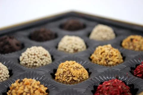Multi-colored chocolates in dark packaging Stock Photos