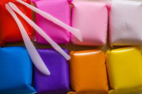 Multi-colored clay for creativity and sculpting on top are plastic knives for Stock Photos