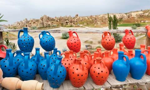 The multi-colored clay pots of desires stand on a wooden table in Cappadocia. Stock Photos