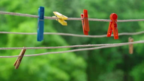 Multi-colored clothespins sway in the wind on the clothesline. Stock Footage 151830880