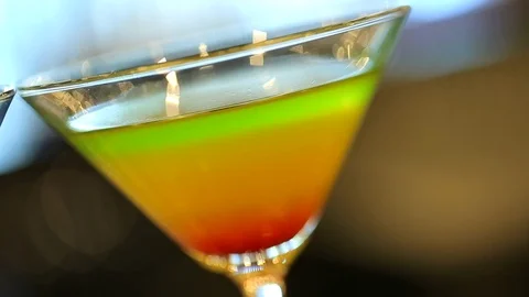 Multi colored cocktail drink in martini glass at bar C Stock Footage 120407835