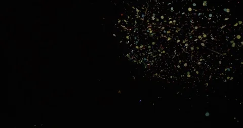 Multi colored confetti scattering in the air on black background Stock Footage 99984575