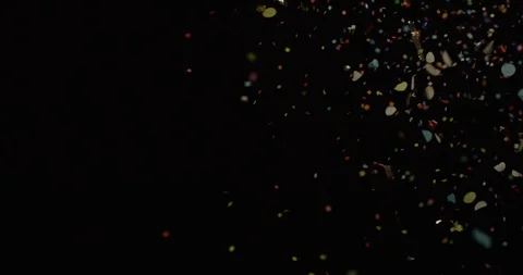 Multi colored confetti scattering in the air on black background Stock Footage 99984676