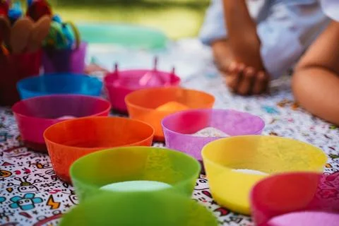 Multi-colored containers with multi-colored sand and small pebbles for children Stock Photos