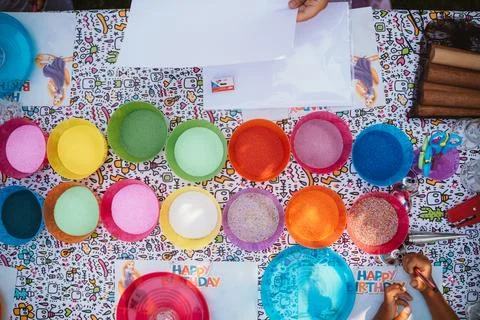 Multi-colored containers with multi-colored sand and small pebbles for children Foto stock