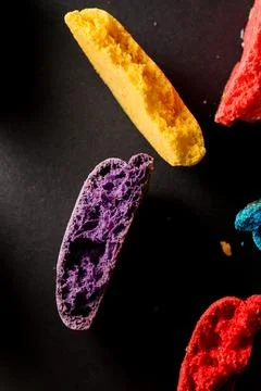 Multi colored crushed halves of macaroons on dark concrete background. Top view Stock-Fotos