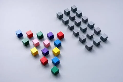 Multi-colored cubes are lined up opposite gray ones. Unity and a common struggle Stock Photos