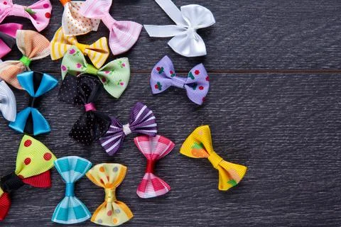 Multi-colored decorative fabric bows on a wooden table top view Stock Photos