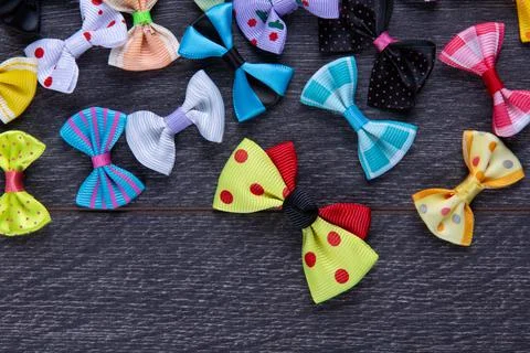 Multi-colored decorative fabric bows on a wooden table top view Stock Photos