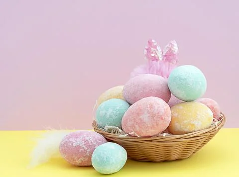 Multi-colored delicate painted Easter eggs with rabbit ears in a wicker baske Stock Photos