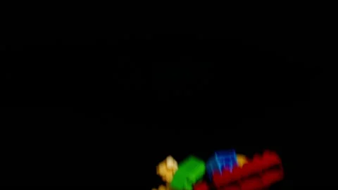 Multi-colored details of the children's designer fly up on a black background Stock Footage 148337360