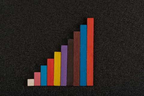 Multi-colored diagram on black background. Triangle of wooden pieces. Stock Photos