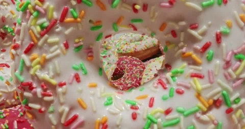 Multi colored donuts with sprinkles. Table with donuts and coffee. Video stock 165442793