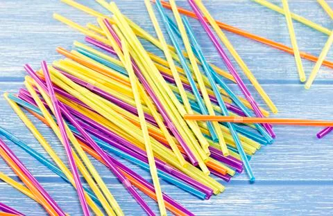 Multi-colored drinking straws on a blue background Stock Photos