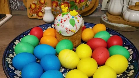 Multi-colored Easter chicken eggs on a platter with Easter cake Stock Footage 243573142