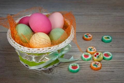 Multi-colored Easter eggs and sweets in a beautiful basket. Foto stock