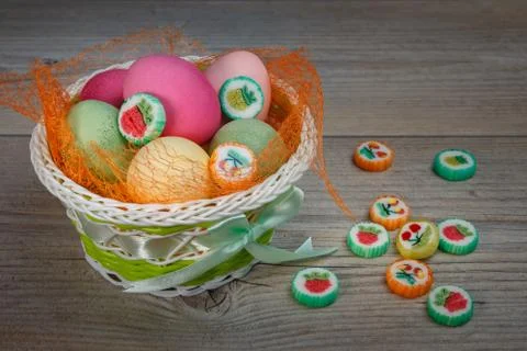 Multi-colored Easter eggs and sweets in a beautiful basket. Stock-Fotos