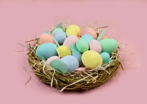 Multi-colored Easter eggs and feathers in pastel colors lie in a nest of Stock Photos