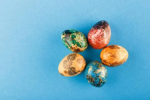 Multi-colored easter eggs are laid out around. Stock Photos