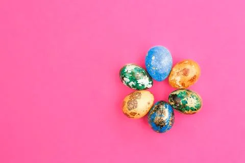 Multi-colored easter eggs are laid out around. Stock Photos