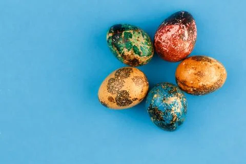 Multi-colored easter eggs are laid out around. Stock Photos