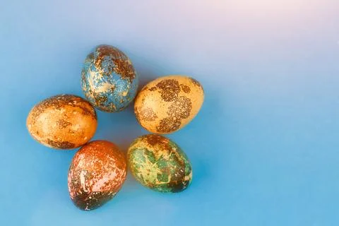 Multi-colored easter eggs are laid out around. Stock Photos