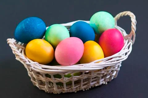Multi colored Easter eggs in basket Stock Photos