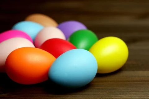 Multi colored easter eggs on dark wooden planks table close up view 스톡 사진
