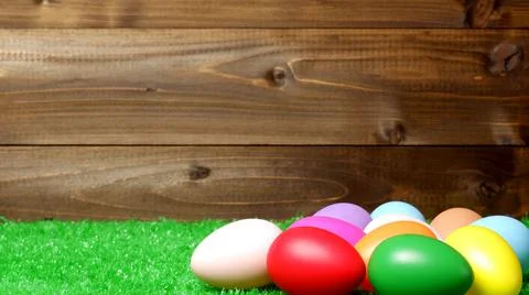 Multi colored easter eggs on green grass lawn and wooden planks background 스톡 사진