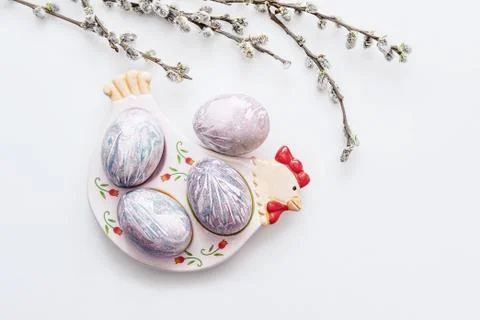 Multi-colored Easter eggs lie on a plate in the form of a chicken on a light Stock Photos