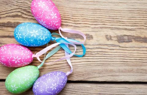 Multi-colored Easter eggs lie  on a rough wooden background Stock Photos