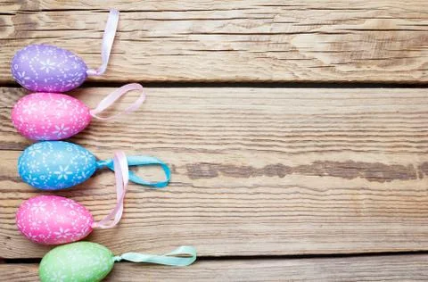 Multi-colored Easter eggs lie  on a rough wooden background Stock Photos