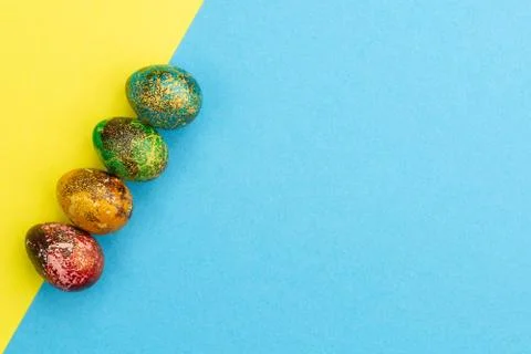 Multi-colored Easter eggs lie in a row. Stock Photos