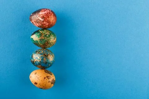 Multi-colored Easter eggs lie in a row. Stock Photos