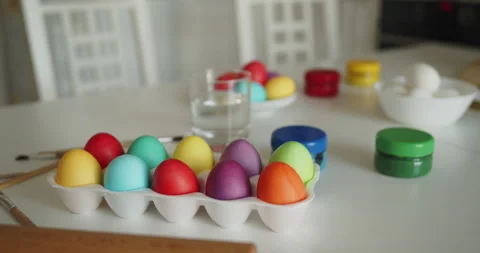 Multi-colored easter eggs, paint jars and brushes on a kitchen table Stock Footage 236794238