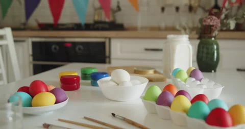 Multi-colored easter eggs, paint jars and brushes on a kitchen table Stock Footage 236794644