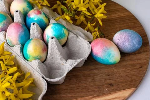 Multi-colored Easter eggs on a wooden background, a green background next to  Stock Photos