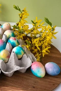 Multi-colored Easter eggs on a wooden background, a green background next to  Stock Photos