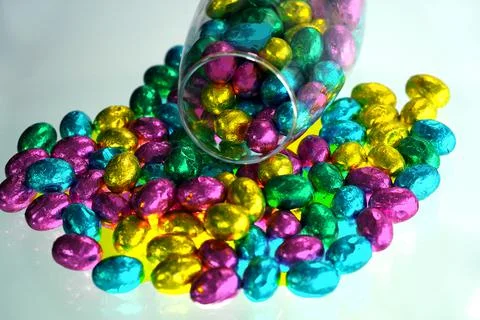 Multi-colored Easter eggs wrapped in foil. Stock Photos