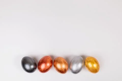 Multi-colored eggs on a uniform white background with place for text. Stock Photos